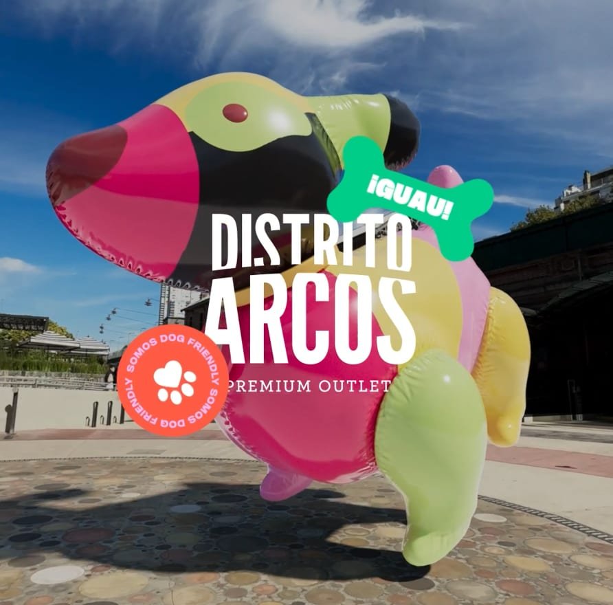 Perro inflable gigante flotando sobre el patio de Distrito Arcos, con la placa Somos Dog Friendly