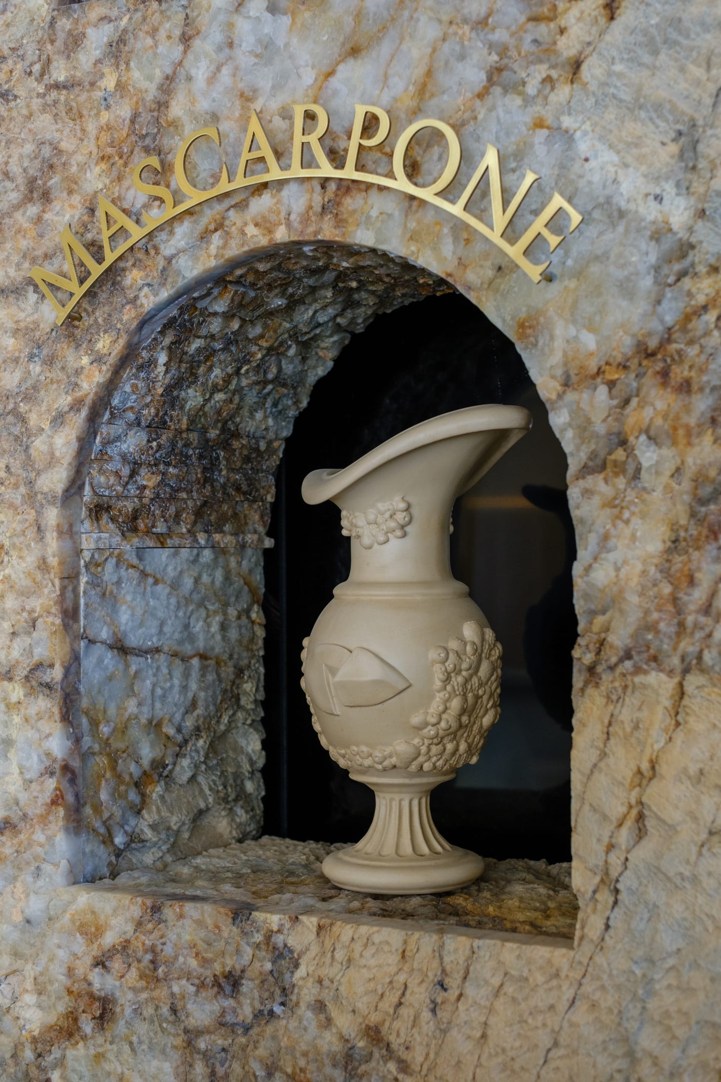 Mascarpone niche with brass lettering above the arch